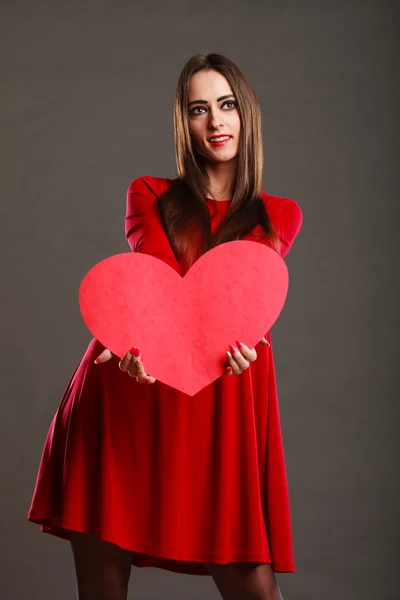 Menina segurando sinal de amor coração vermelho — Fotografia de Stock