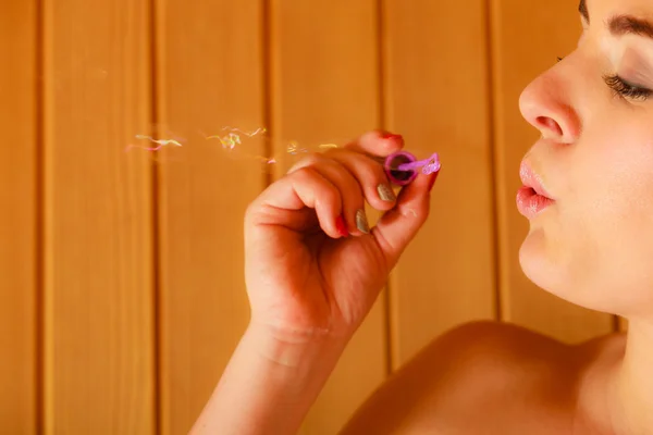 Mujer relajante en sauna habitación soplando burbujas de jabón —  Fotos de Stock