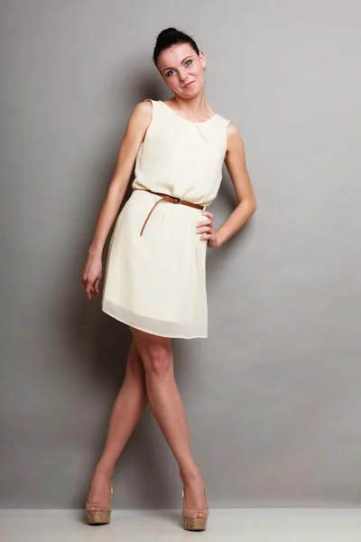 Glamour flicka i vit klänning på grå — Stockfoto