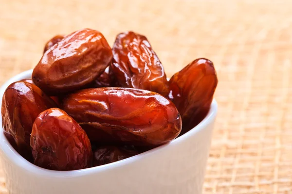 Dried dates in bowl on table background — Stock Photo, Image