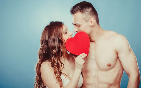 愛情のあるカップルが赤いハートの後ろにキスします。愛. — ストック写真