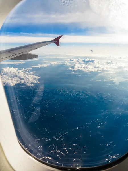 Nuages et ciel vus à travers la fenêtre d'un aéronef — Photo