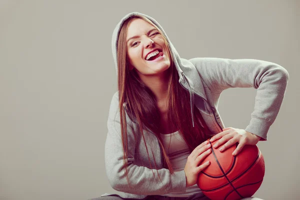 Sportliches Teenie-Mädchen in Kapuze hält Basketball. — Stockfoto