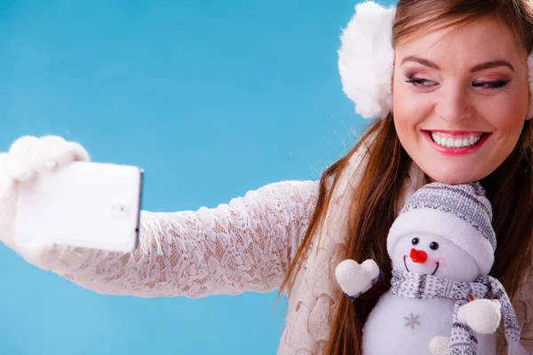 Mujer con pequeño muñeco de nieve tomando foto selfie . — Foto de Stock