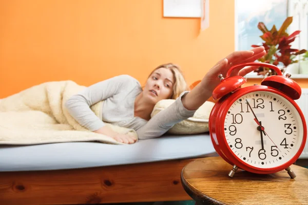 Woman waking up turning off alarm clock in morning — Stock Photo, Image