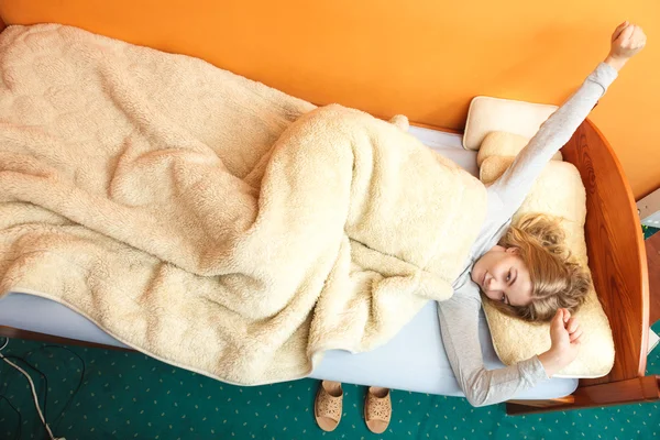 Mujer estirándose en la cama por la mañana después de dormir — Foto de Stock