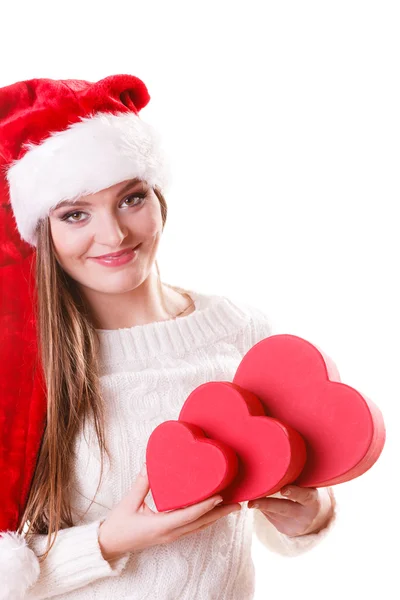 Girl santa helper hat holds heart shaped gift boxes — Stock Photo, Image