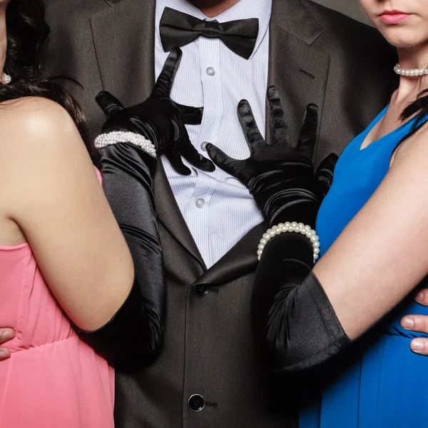 Чоловік у костюмі і дві елегантні жінки в сукнях . — стокове фото