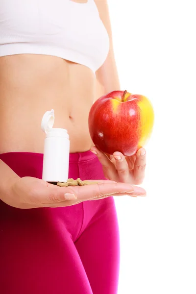 Mujer sosteniendo vitaminas y manzana. Asistencia sanitaria. — Foto de Stock