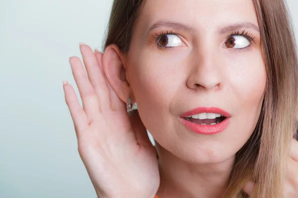 Gossip girl eavesdropping with hand to ear. — Stock Photo, Image