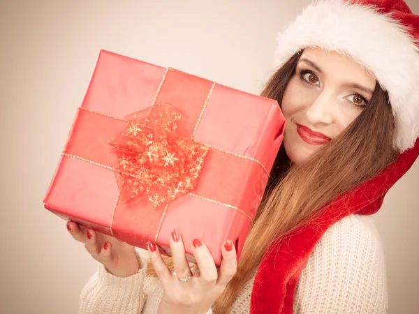 Mujer en sombrero de ayudante santa sostiene caja de regalo roja — Foto de Stock