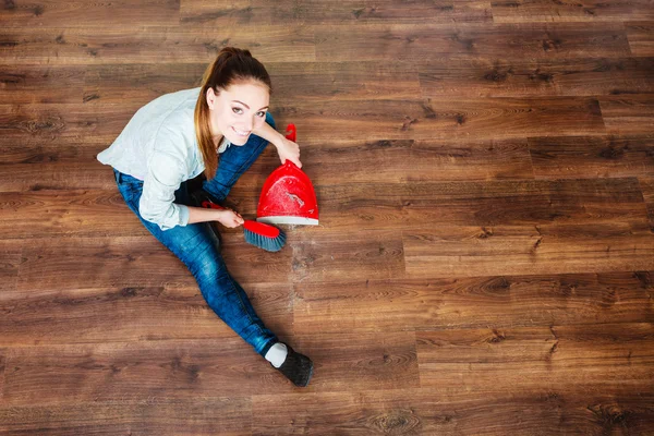 Putzfrau fegt Holzboden — Stockfoto