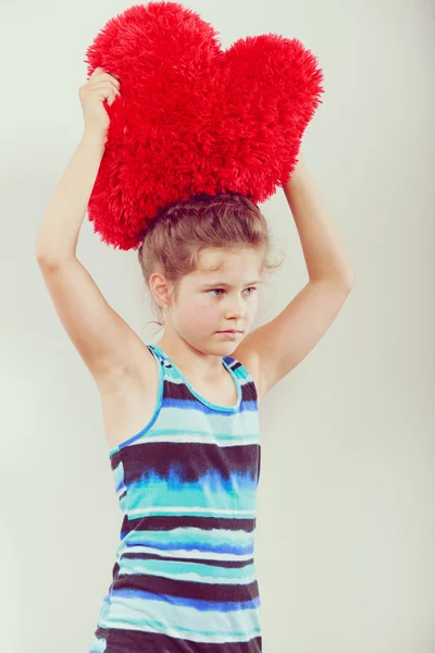 Niña con almohada roja en forma de corazón . — Foto de Stock