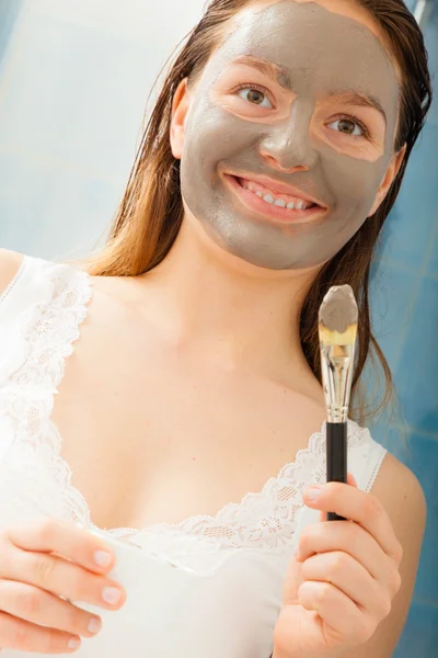 Kvinnan tillämpa ansiktsbehandling grå lera lera mask — Stockfoto
