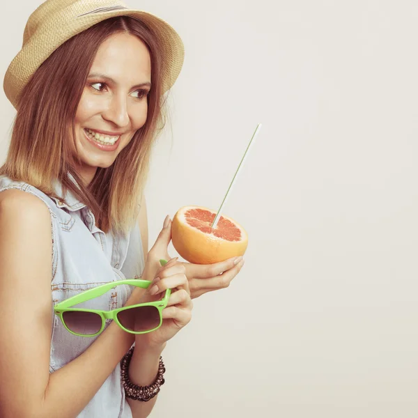 Lycklig kvinna i hatt innehar solglasögon och grapefrukt — Stockfoto