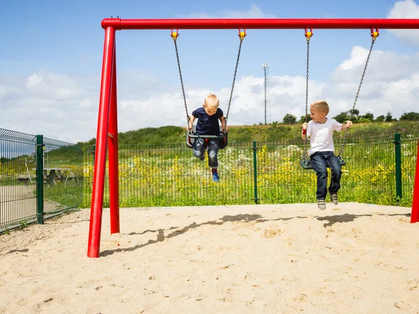 Children boys playing on swing outdoor. — Stock Photo, Image