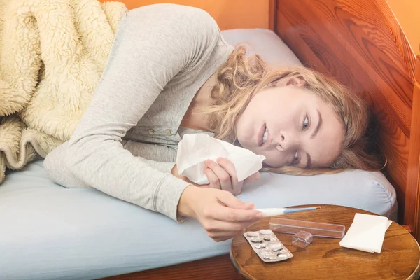 Mujer en la cama estornudando en tejido . —  Fotos de Stock