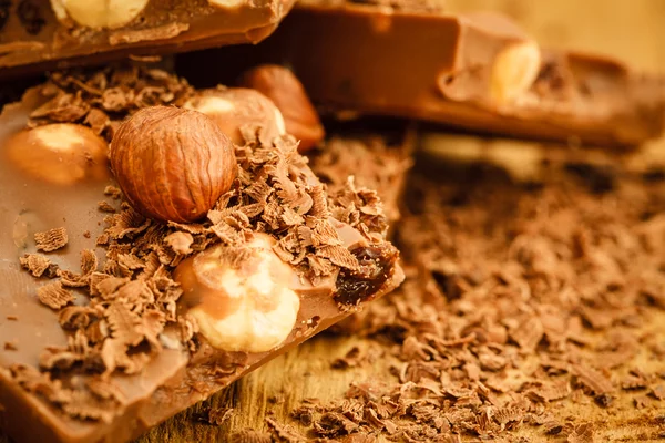 Trucioli di cioccolato e pezzi su tavolo di legno — Foto Stock