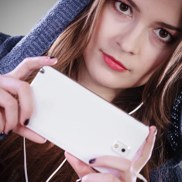 Nuori nainen älypuhelimella kuuntelee musiikkia — kuvapankkivalokuva