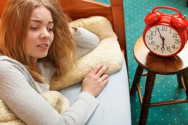 Woman waking up turning off alarm clock in morning — Stock Photo, Image