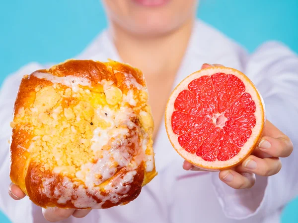 Nutritionist innehar en kaka och frukt — Stockfoto