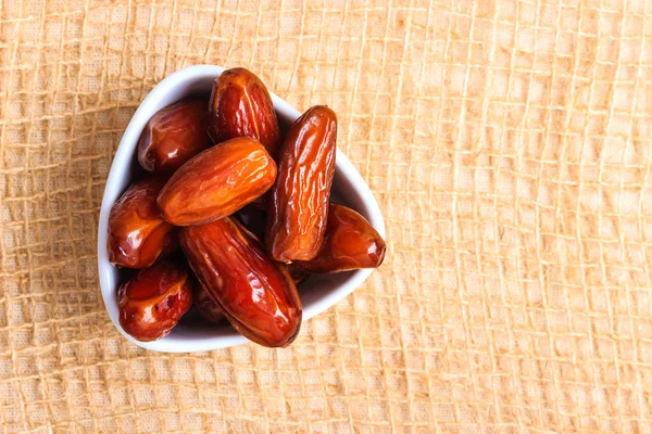 Dried dates in bowl on table background — Stock Photo, Image