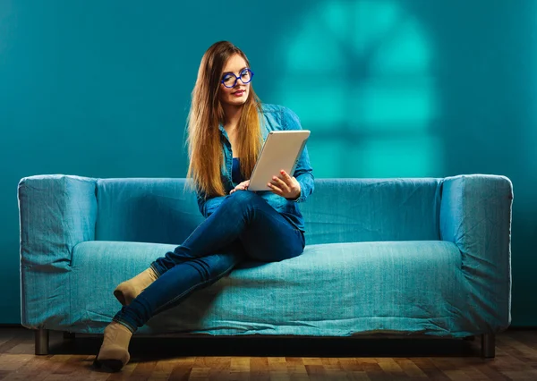 Mulher com tablet sentado no sofá cor azul — Fotografia de Stock