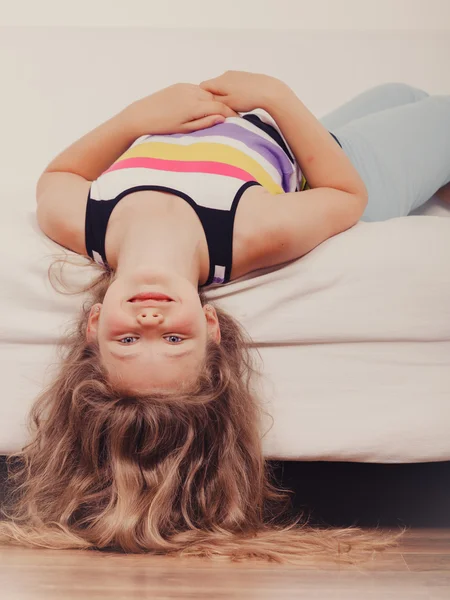 Little girl kid with long hair upside down on sofa — Stock Photo, Image