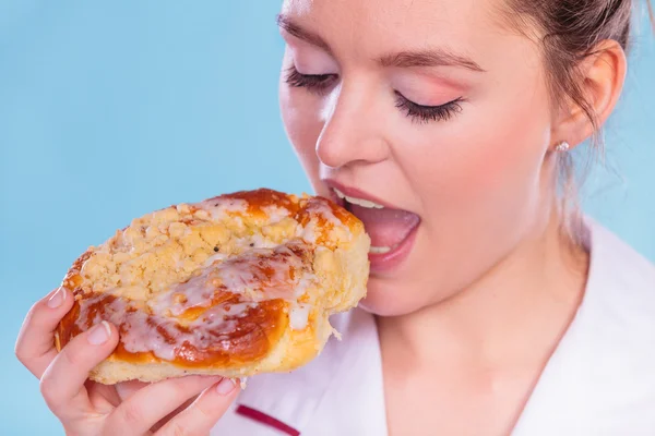 Ernährungsberaterin isst süße Brötchen. Ungesunde Ernährung. — Stockfoto