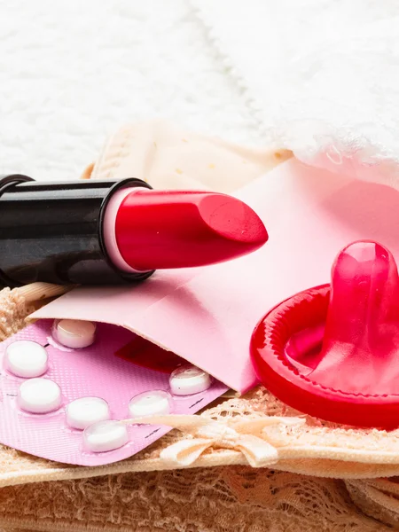 Pills condom and lipstick on lace lingerie — Stock Photo, Image