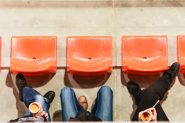 Row of plastic chairs and legs — Stock Photo, Image