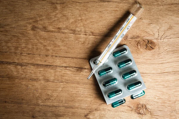 Pills  and mercury thermometer. — Stock Photo, Image