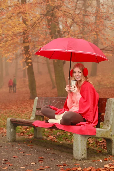 Mujer tomando café caliente relajándose en el parque de otoño — Foto de Stock