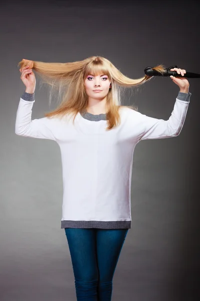 ヘアアイロンでヘアスタイルを作る女性 — ストック写真