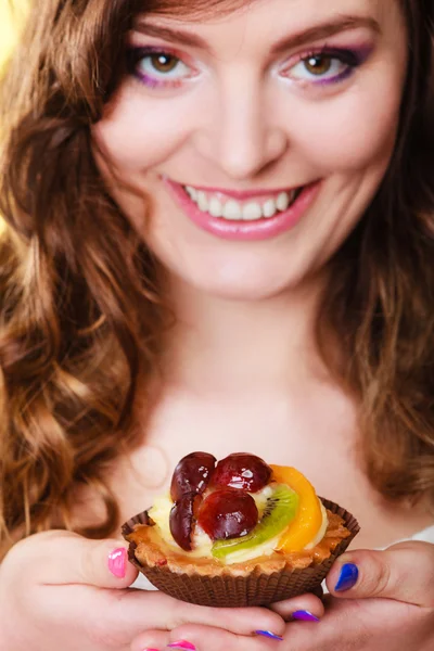 Smiling cute woman holds fruit cake in hand — Stock Photo, Image