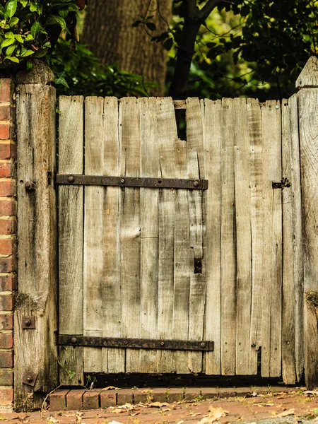 Puerta de madera vieja rústica en pared de ladrillo — Foto de Stock