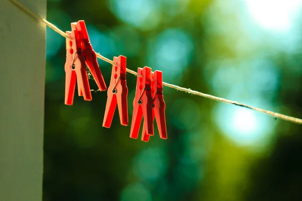 Rojo ropa clavijas en cadena al aire libre . — Foto de Stock