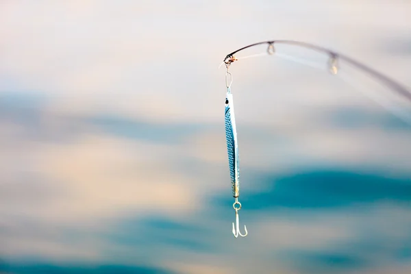 Saltwater fishing - rod with wobbler and blue sea water — Stock Photo, Image