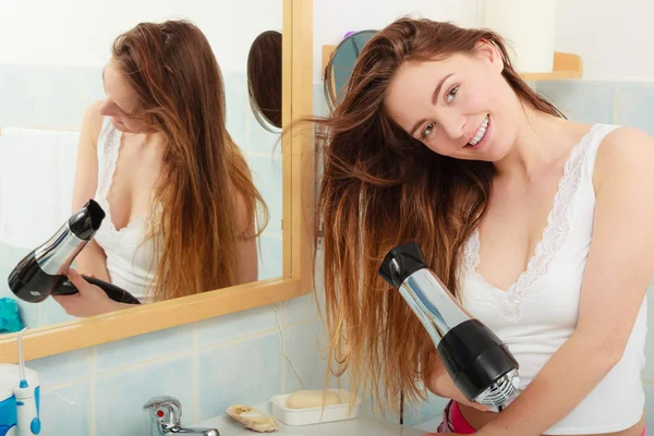 Mulher de cabelos longos secando o cabelo no banheiro — Fotografia de Stock