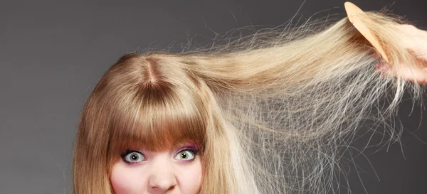 Donna pettinando i capelli danneggiati — Foto Stock