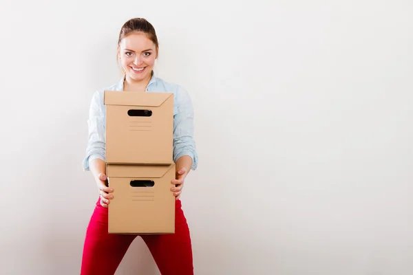 Mujer mudándose a la casa del apartamento llevando cajas . — Foto de Stock