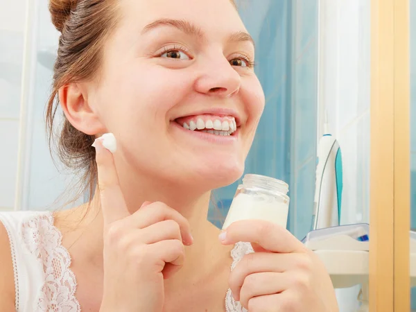 Mulher aplicando creme hidratante para a pele. Tratamento da pele . — Fotografia de Stock