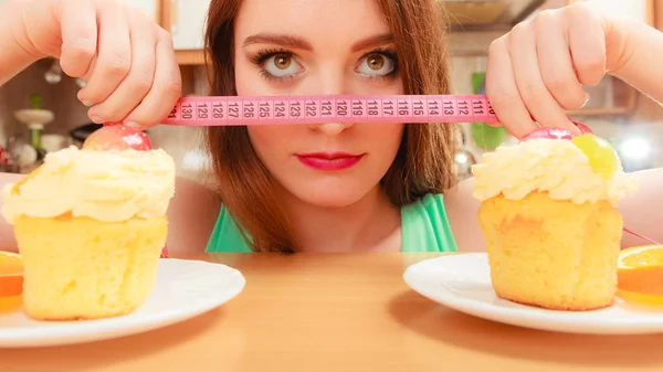 Woman with tape measure and cake. Diet dilemma. — Stock Photo, Image