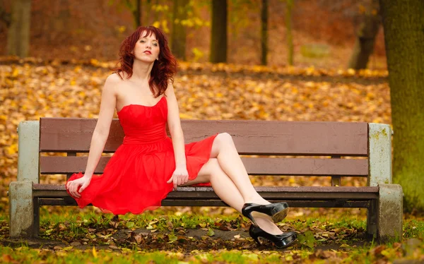 Frau im eleganten roten Kleid sitzt — Stockfoto