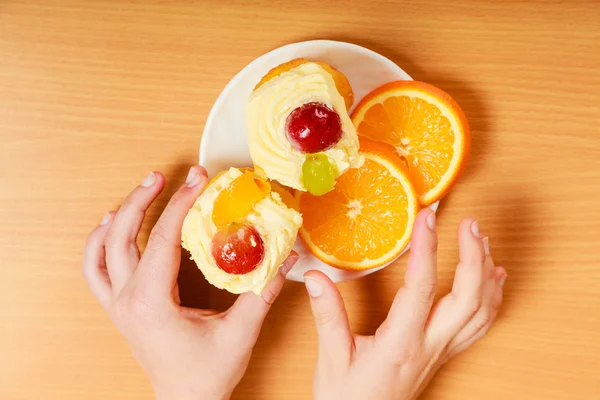 Руки беруть гастрономічне кремове печиво та апельсин — стокове фото