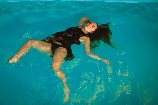 Femme flottant dans la piscine — Photo