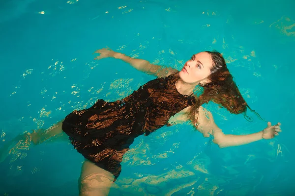 Woman floating  in swimming pool — Stock Photo, Image