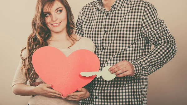 Paar hält sich Papierschlüssel zu Herzen — Stockfoto