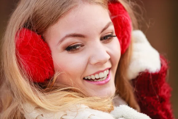 Porträt einer hübschen lächelnden Frau mit roten Ohrenschützern. — Stockfoto