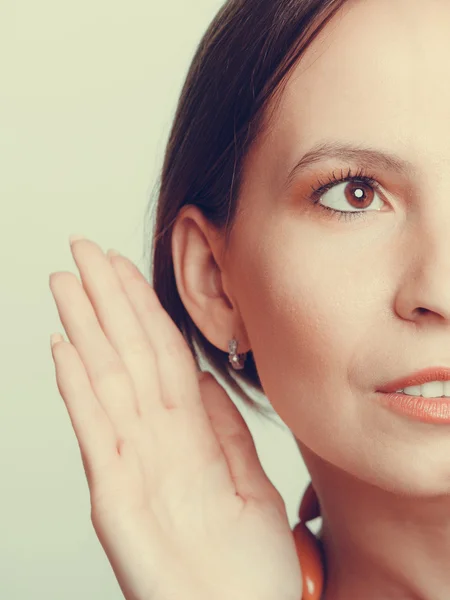 Chica espiando con la mano a la oreja — Foto de Stock